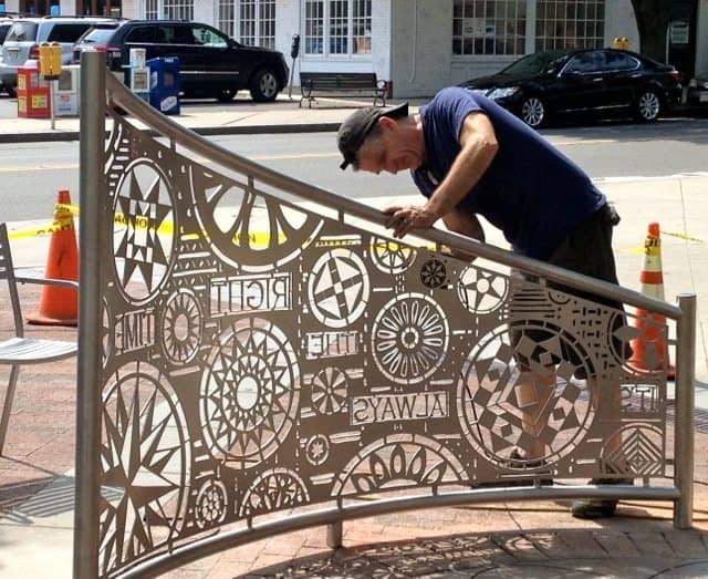 Tom Nussbaum polishes the newly installed stainless steel gates on Hinds Plaza Wednesday. 