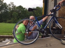 Bill Hogan, 90, president emeritus of the Anchor House Foundation, get a hug from cyclist Kilani DiGiacomo of Lawrence as he helps her load her bike Thursday night. 