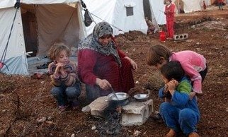 A refugee cooks in font of her tent in the refugee camp © Freedom House on Flickr, used under Creative Commons License.